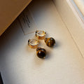 A pair of round geometric tigereye gemstone earrings with real gold plating in a French retro style.