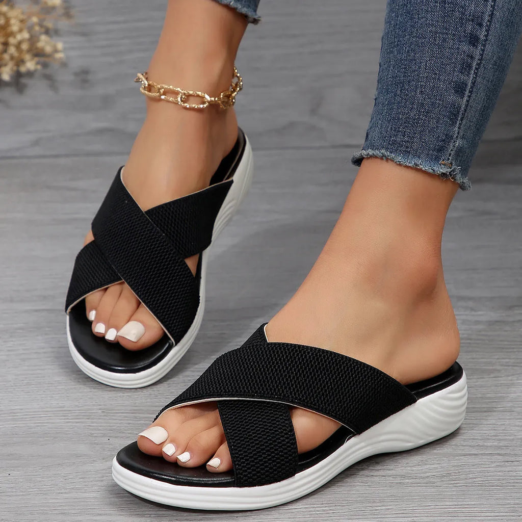Black women's wedge peep-toe summer slippers with cross straps and a thick rubber sole.