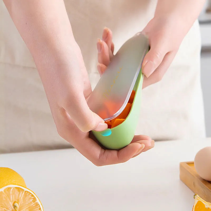 Dark green vegetable peeler with a storage tube and stainless steel blade on a kitchen counter.