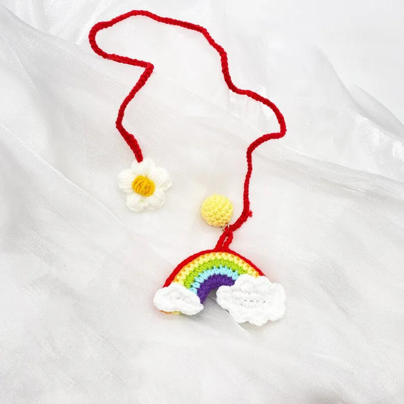 Handmade crocheted rainbow flower car pendant in wool yarn with avocado, pink, and red colour options