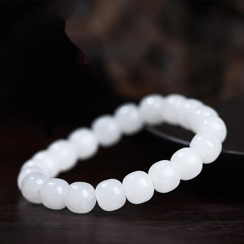 White Hetian jade barrel beads bracelet laid flat, showing unisex design and bead detail.