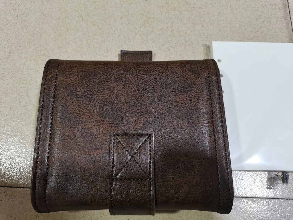 Brown A7 size notebook with a retro leather-look PU cover and metal buckle closure, lying open on a desk.