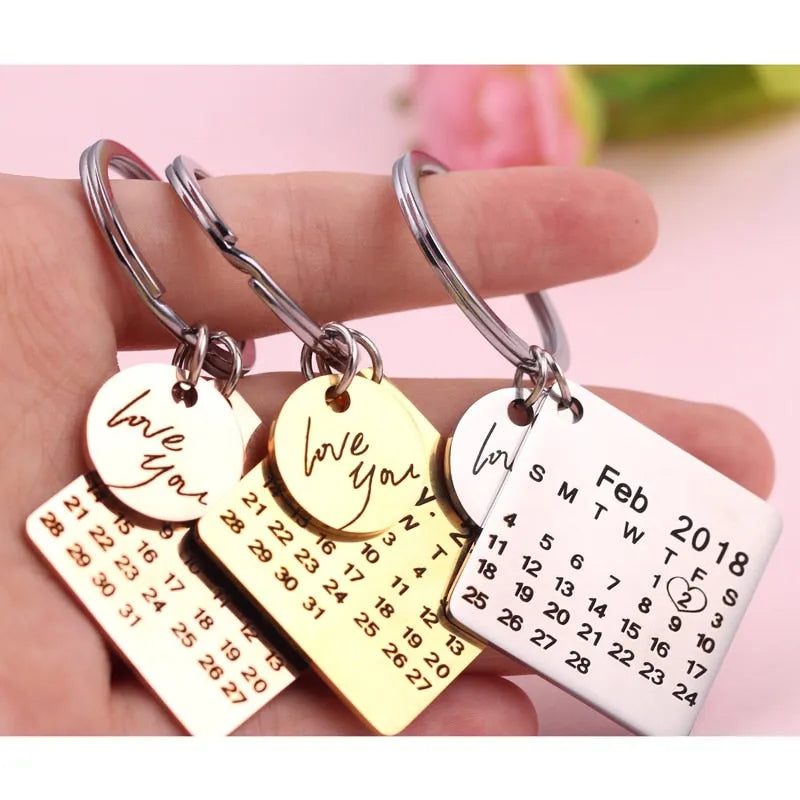 Stainless steel calendar keychain with custom engraved date in silver finish on neutral background