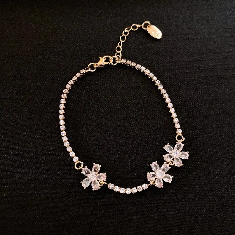 Gold-coloured women's bracelet with geometric quadrilateral design and zircon stone inlays