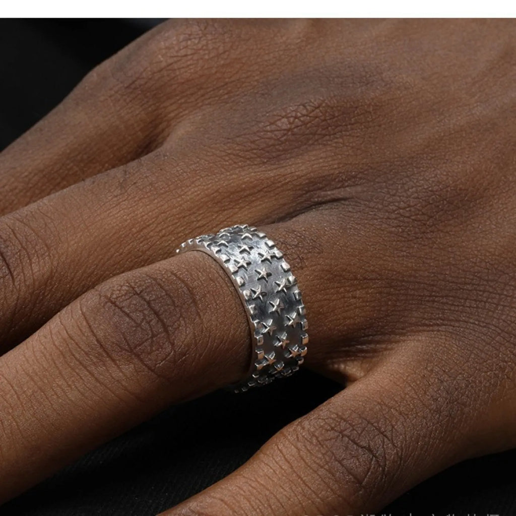 Adjustable sterling silver ring featuring a raised five-pointed star geometric pattern on the band.