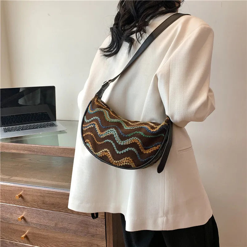 Women's knitted straw woven crossbody bag showing internal phone and file compartments