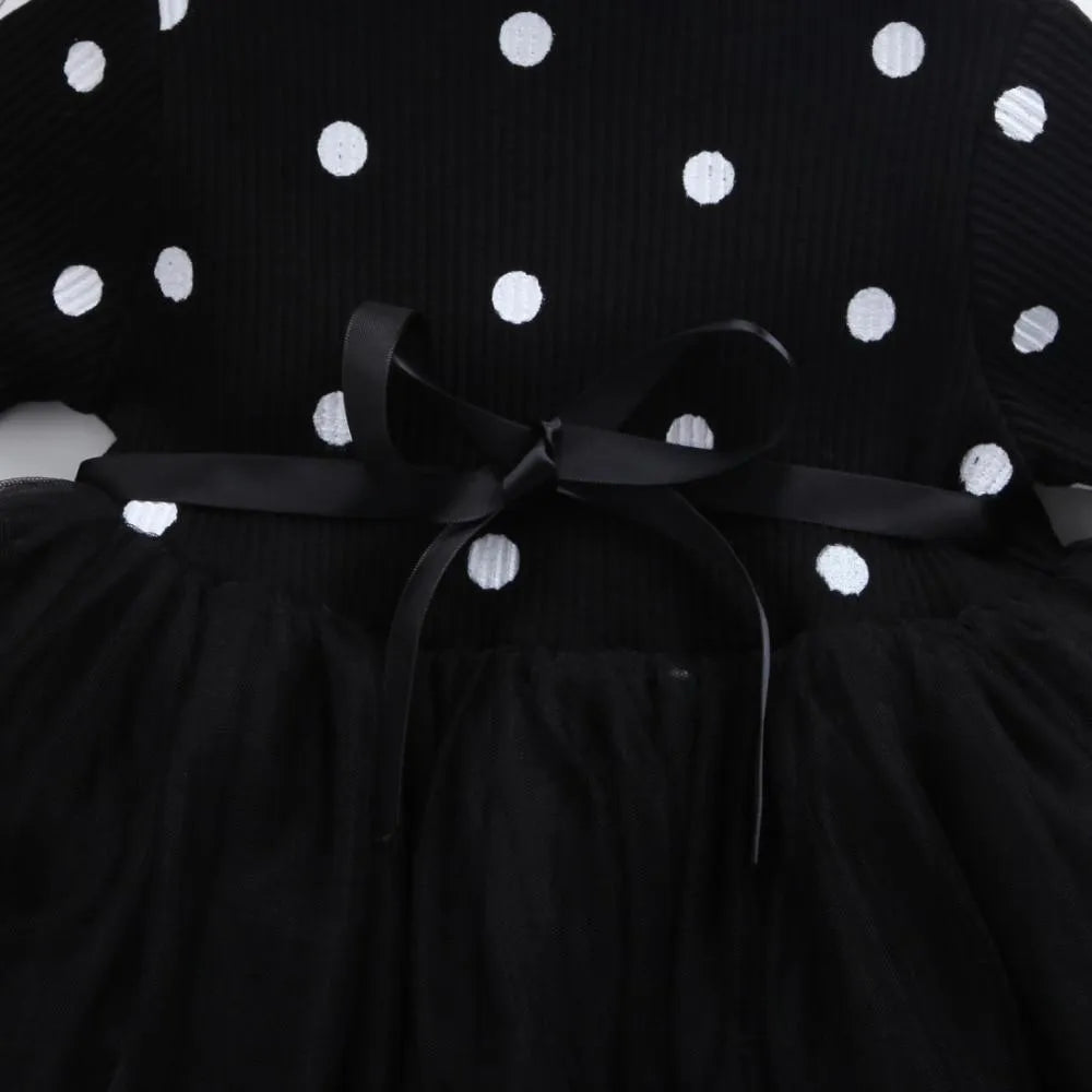 A baby girl's long sleeve black tutu dress with lace detail, suitable for birthdays and christenings.