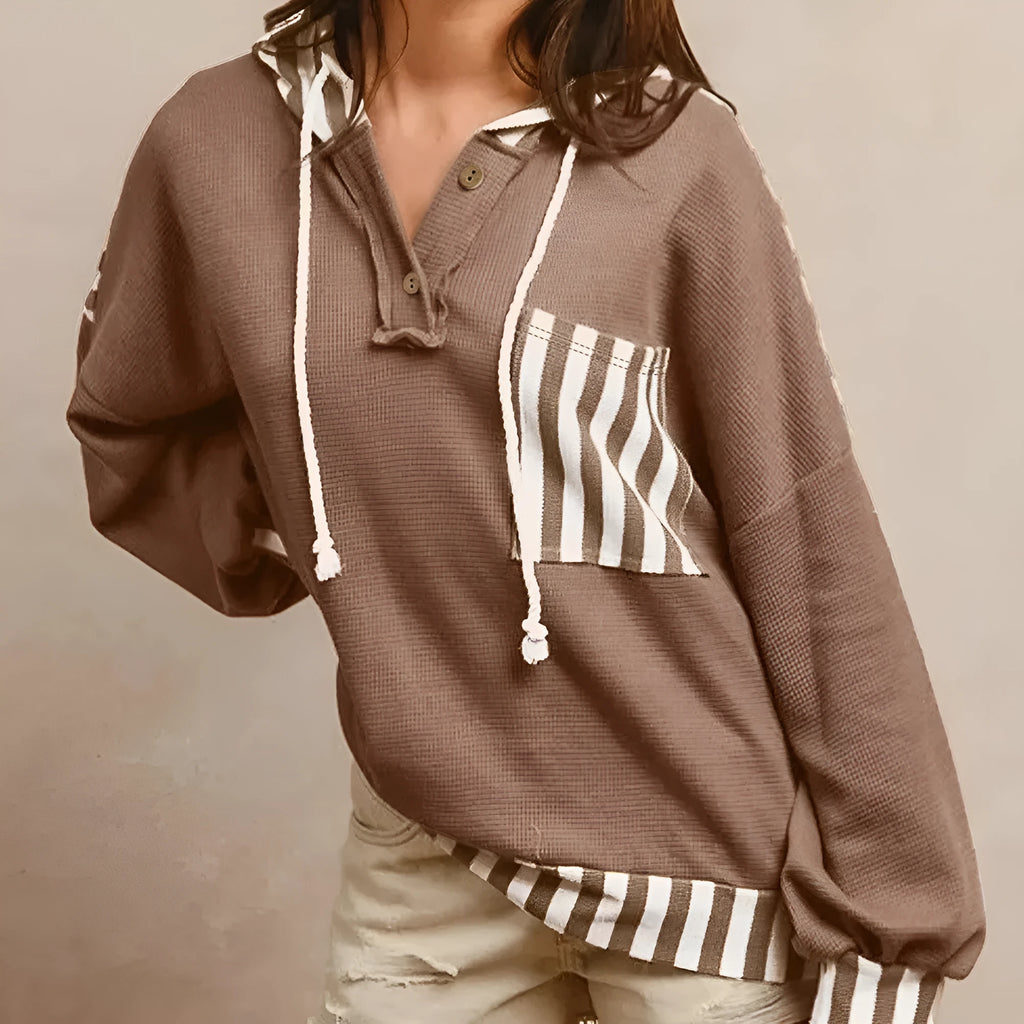 Straw yellow hoodie with striped patchwork design, waffle texture, button neck, and drawstring hood.