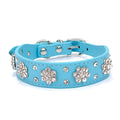 Close-up of a black PU leather dog collar with a sparkling rhinestone flower pattern and silver studs.