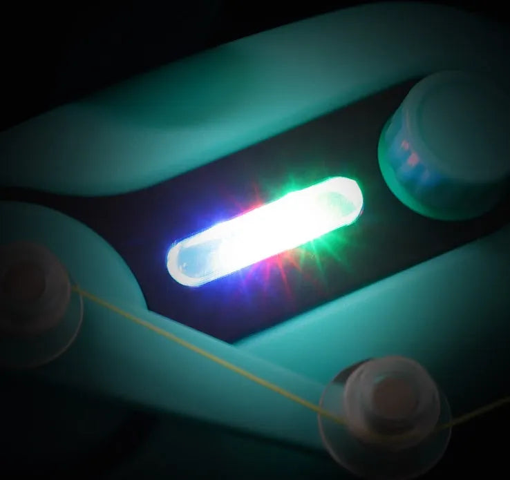 Blue electronic fishing bite alarm with LED light and buzzer attached to a fishing rod