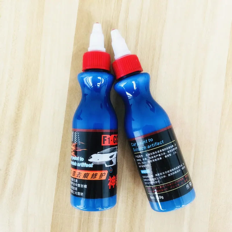 Small blue wiping tool and bottle of automotive scratch repair agent kit for car paint