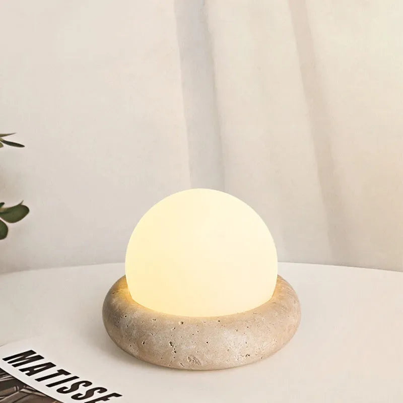 Cream coloured bedside night lamp with remote control on table