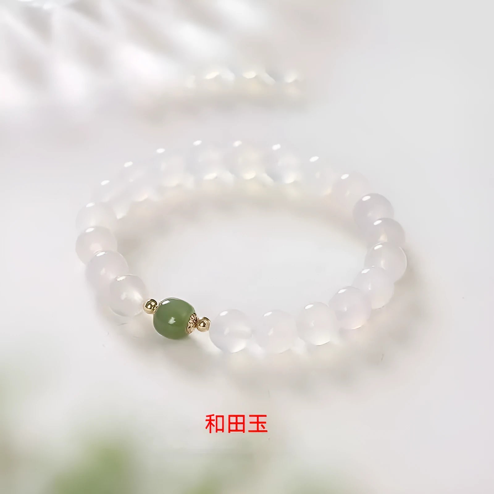 Handmade white agate and crystal bracelet with cinnabar inlay showing letter modelling on 8mm beads.