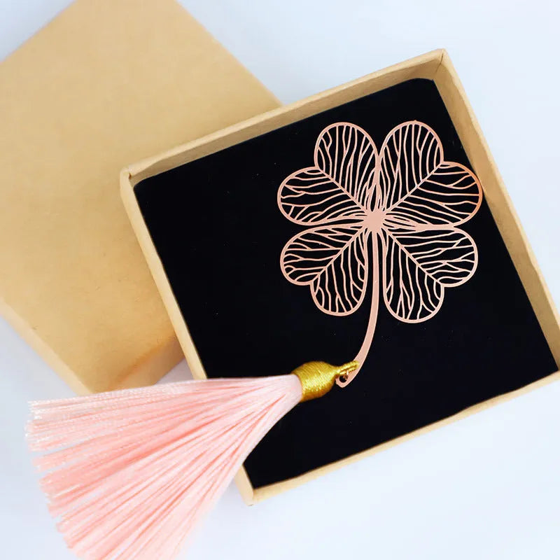 Brass metal bookmark with hollow leaf design and rose gold tassel in a presentation box.