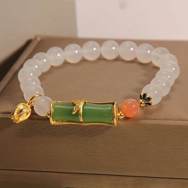 Women's white agate jade bracelet with bamboo joint design and a single bead centrepiece.