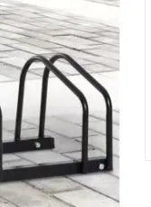 Black metal bicycle parking rack with four card positions holding bicycles upright