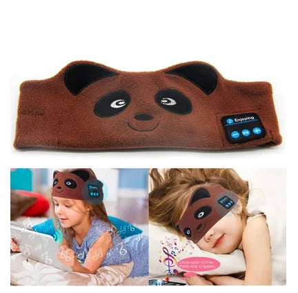 Black Bluetooth sleep mask with built-in speakers lying flat on a surface with a charging cable.