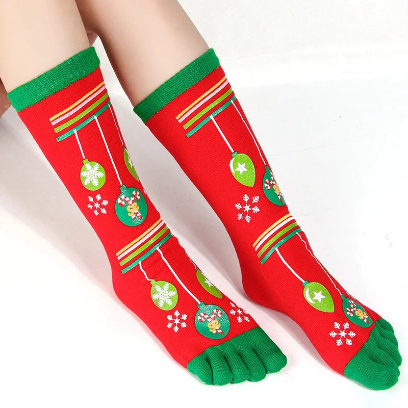 Christmas five finger socks with cartoon patterns in black, green, and white on a neutral background