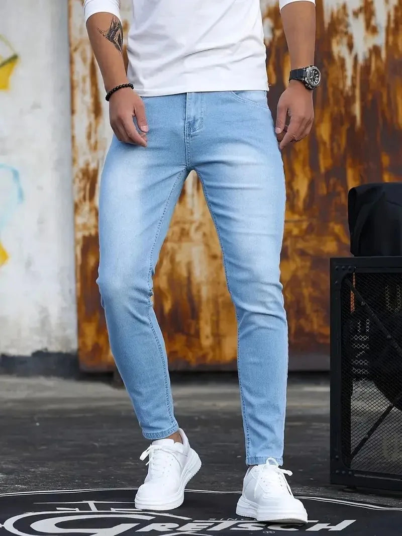 Man wearing retro wash stretch slim fit five-quarter length jeans in blue with zipper and five-pocket design