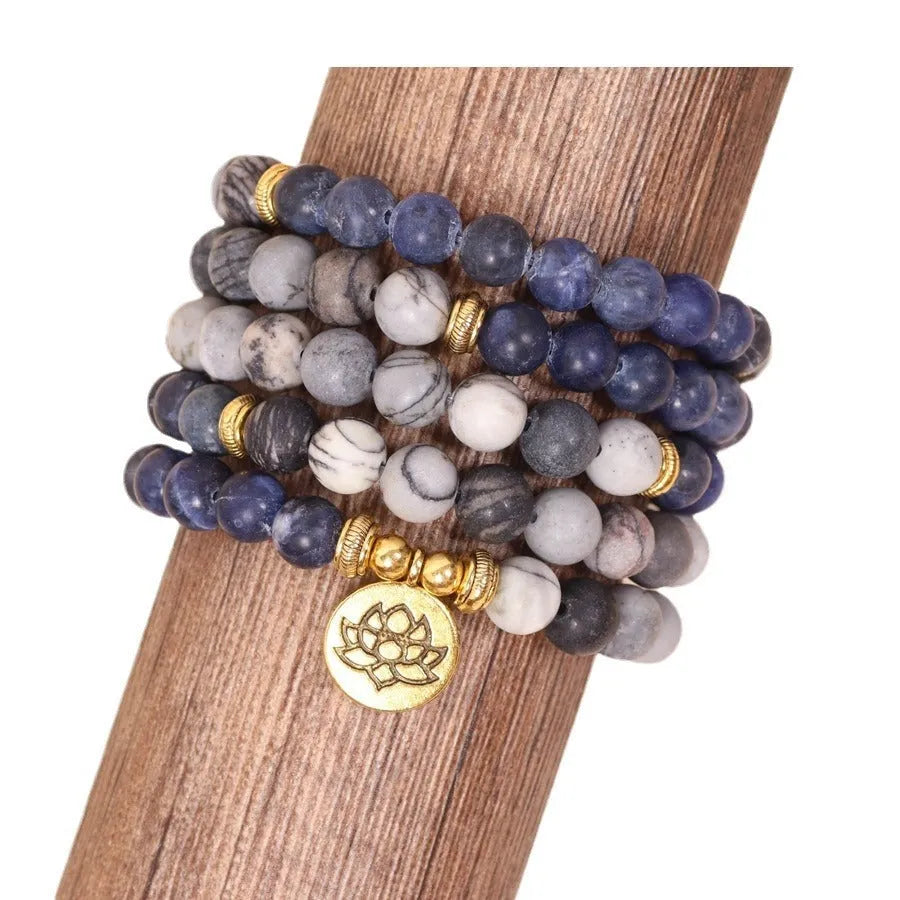 Close-up of a blue multi-layer bracelet with patterned network stone beads and a silver alloy chain.