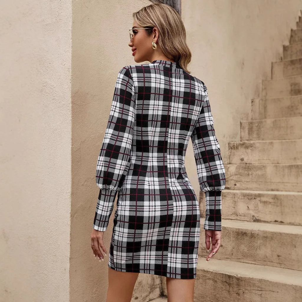 Black tight dress with voluminous lantern sleeves, leather stitching detail, and a printed pattern, mid-length skirt.