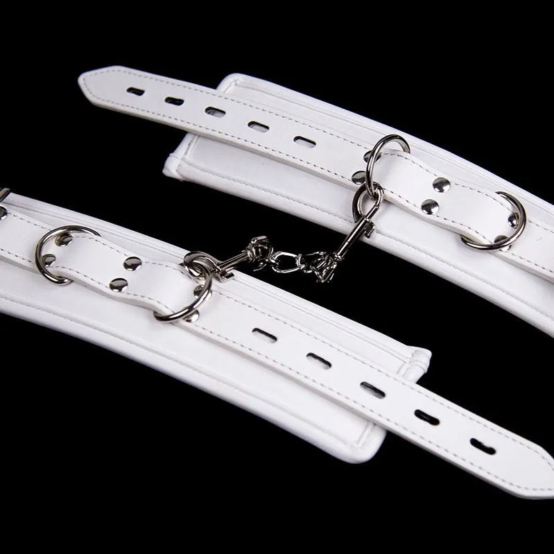 White PU sponge bondage set showing handcuffs, foot cuffs, and neck scarf arranged together