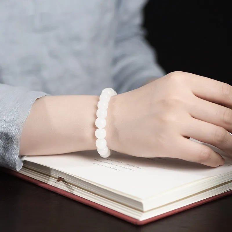 White Hetian jade barrel beads bracelet laid flat, showing unisex design and bead detail.