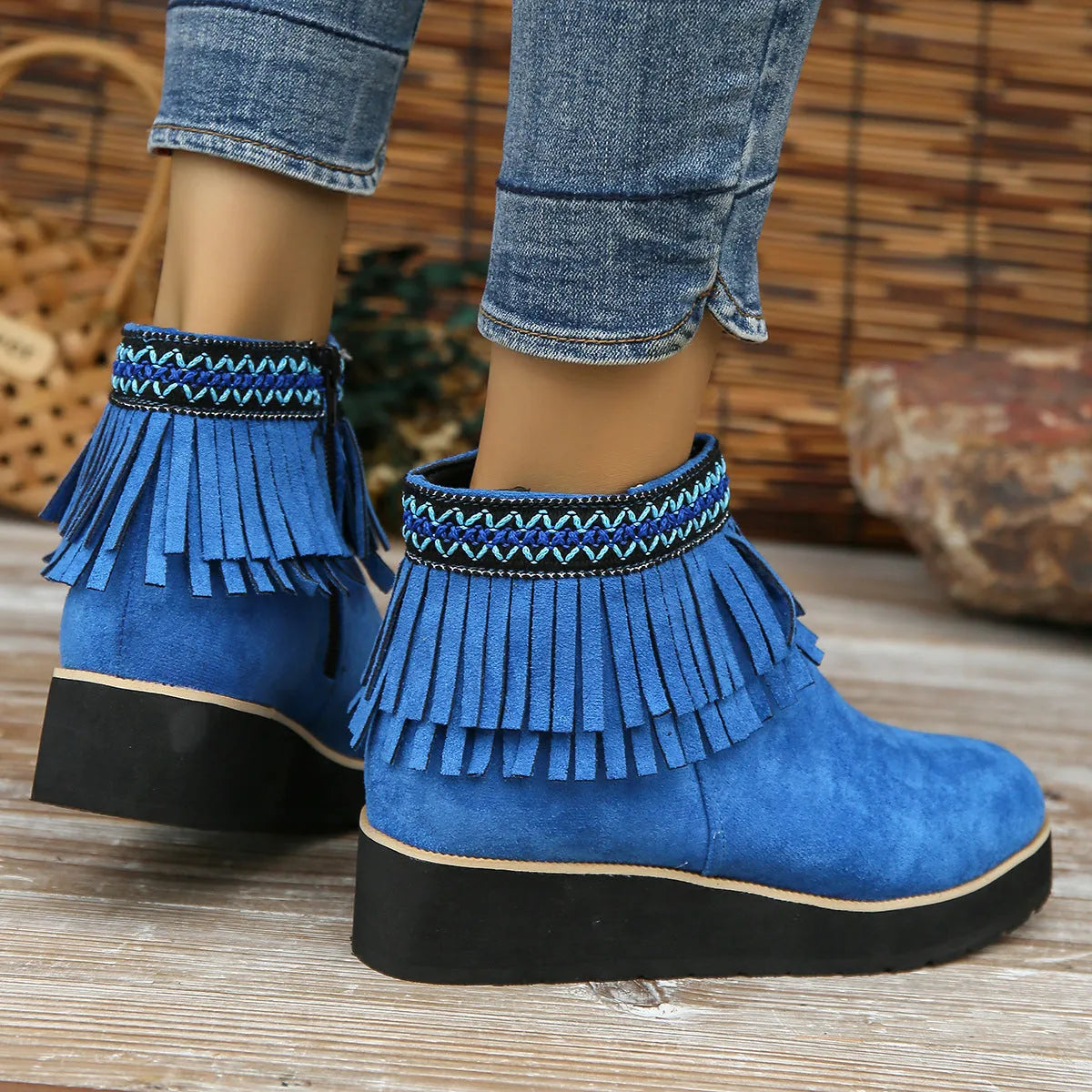 Women's dark brown suede wedge ankle boots with side zipper and tassel detail on a thick rubber sole.