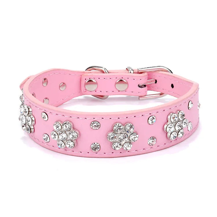 Close-up of a black PU leather dog collar with a sparkling rhinestone flower pattern and silver studs.