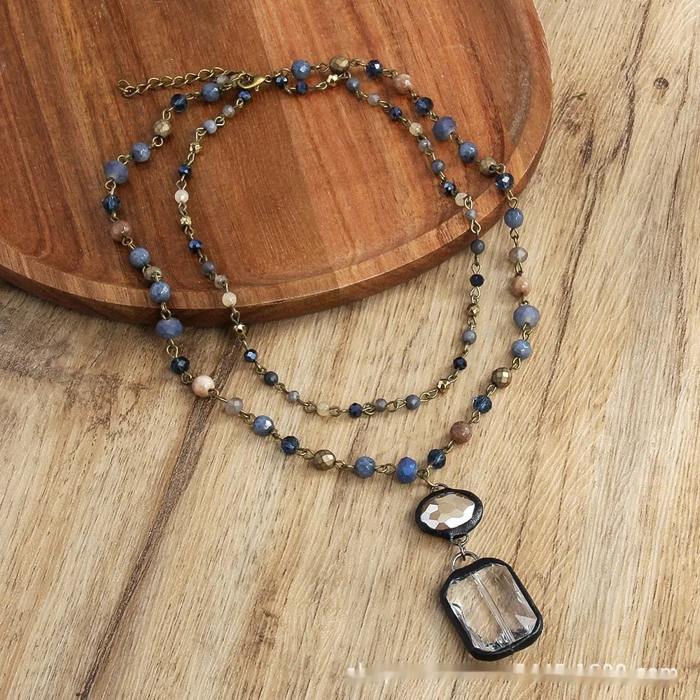 Tribal-style retro necklace with a blue stone and glass pendant on a metal chain.