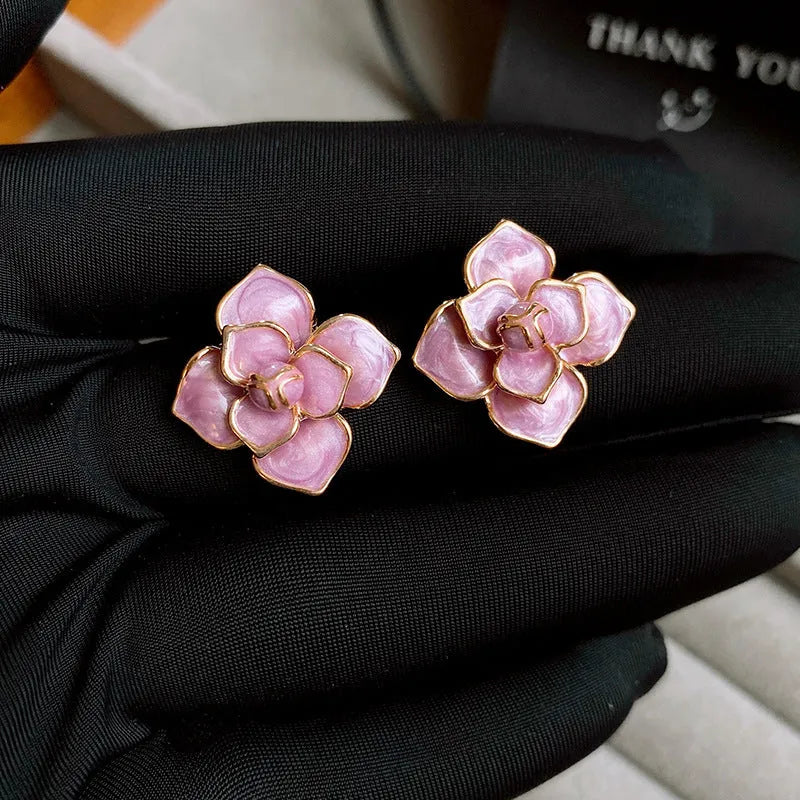 Gold plated flower stud earrings with a purple oil-spot glaze finish on copper.