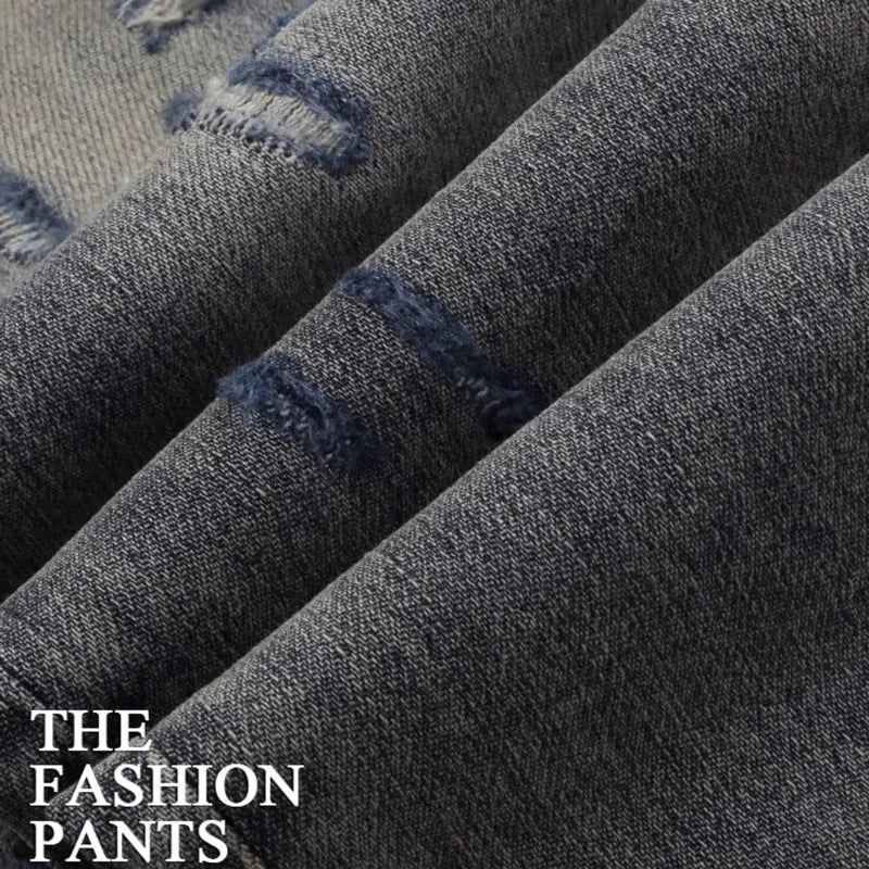 Slim fit light blue jeans with distressed knee patches, embroidery detail, and a faded wash.