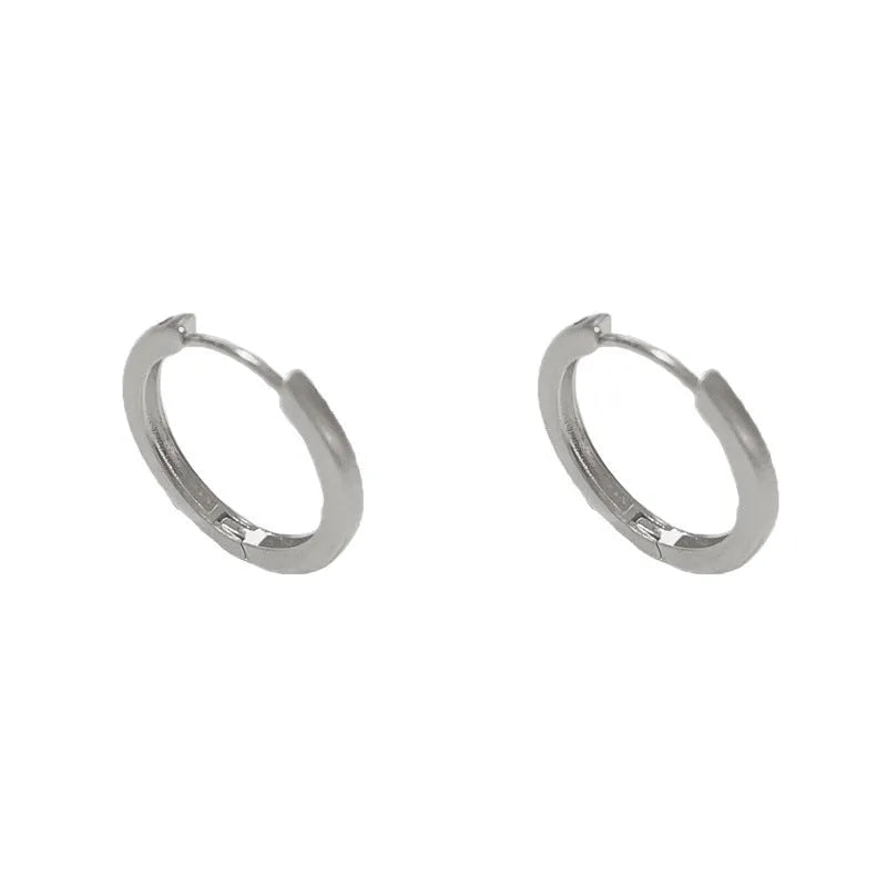 A pair of geometric round eyelet ear clips for women in gold or silver plating.