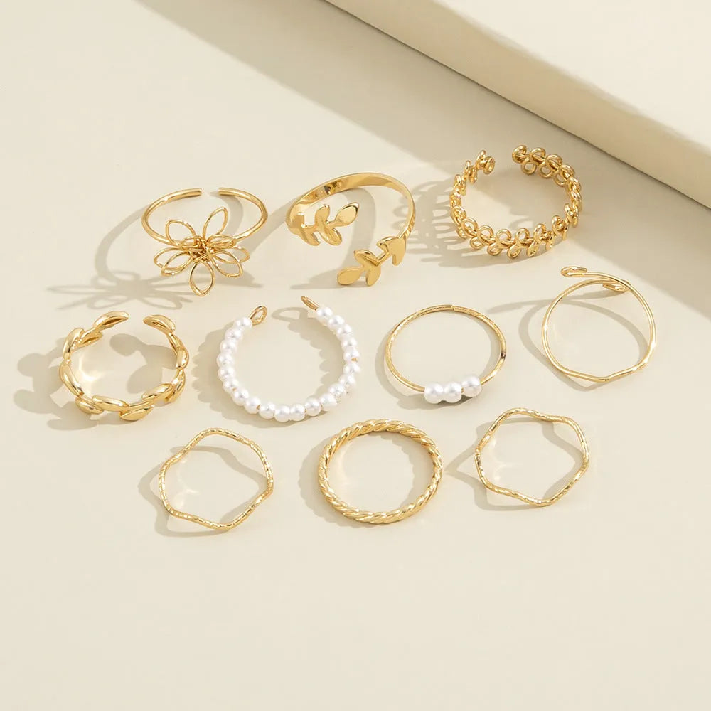 Gold-coloured alloy ring with openwork floral design and glossy electroplated finish