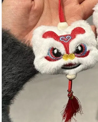 Handmade blue and yellow plush lion keychain ornament with star stone details on a white background.