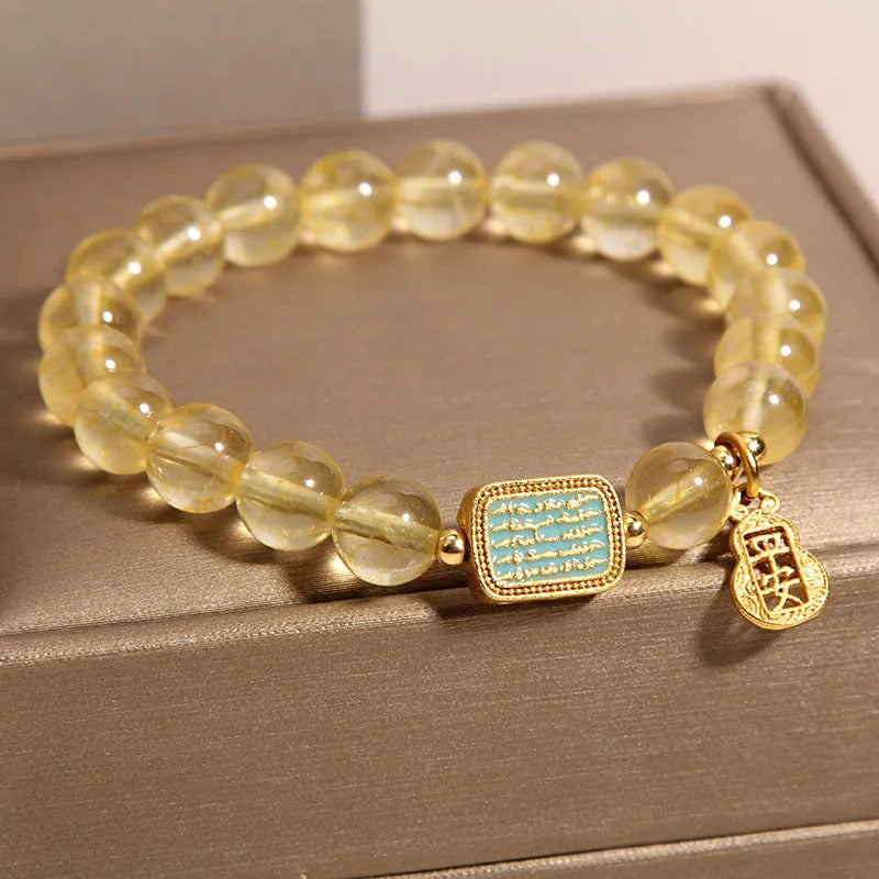 Women's citrine yellow crystal bracelet with rhinestone detailing on a wrist
