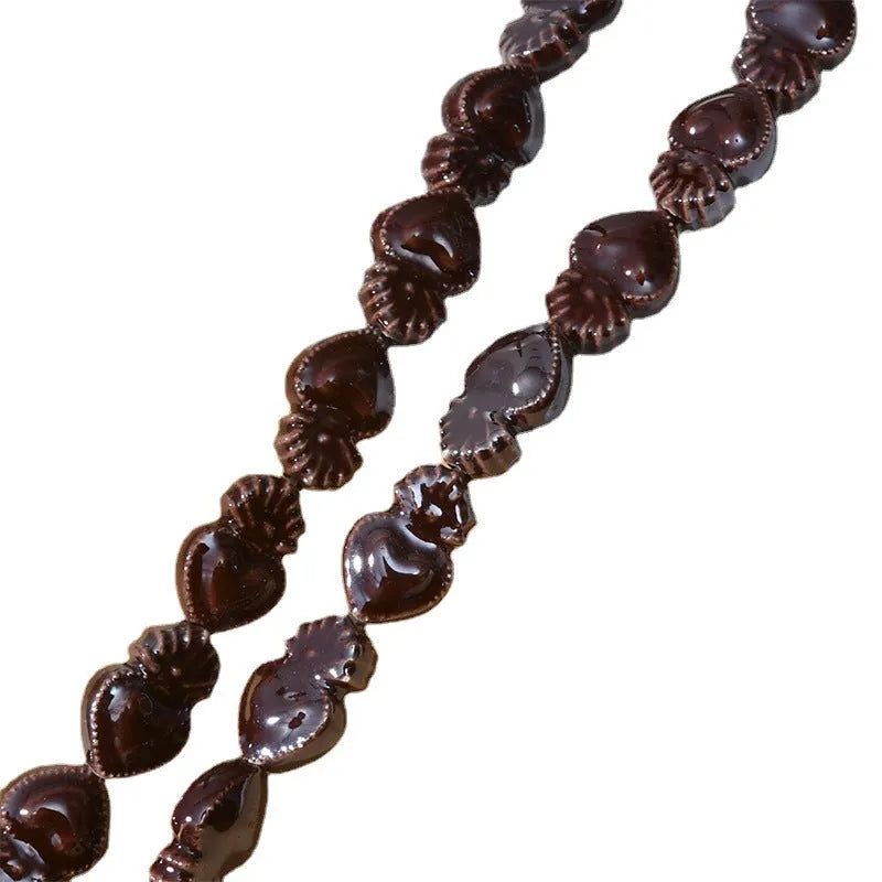Assorted small ceramic torch beads in multiple colours on a white background.