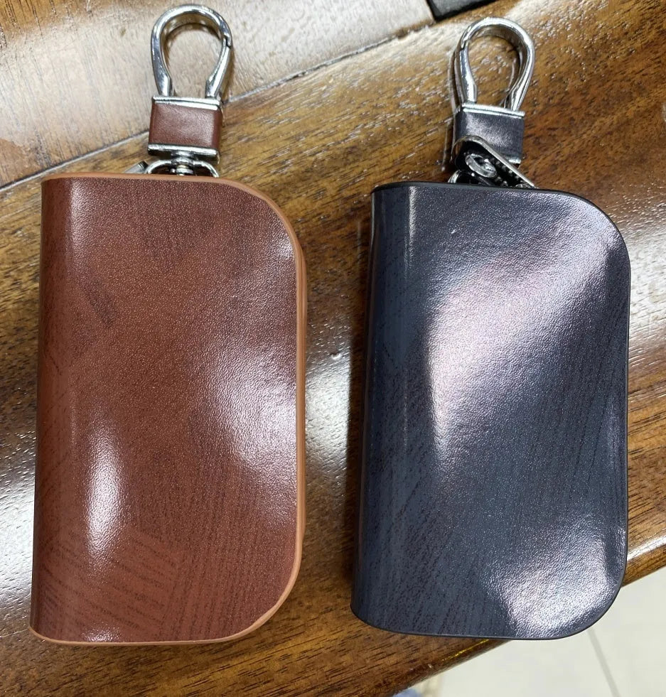 Black genuine leather car key case with a silver V-shaped zipper closed.