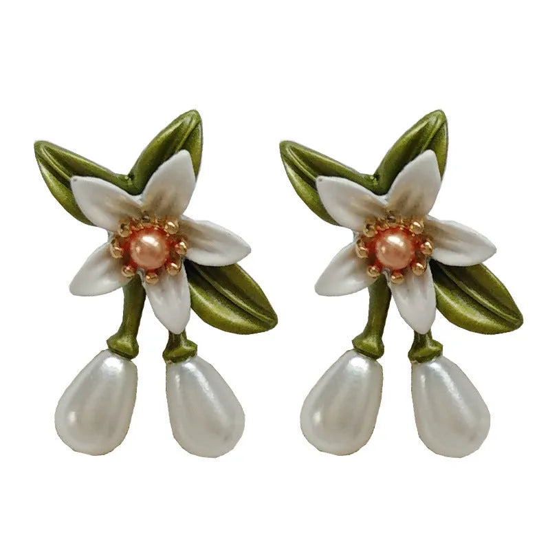 A pair of alloy camellia flower earrings for women, showing both the stud and clip styles.