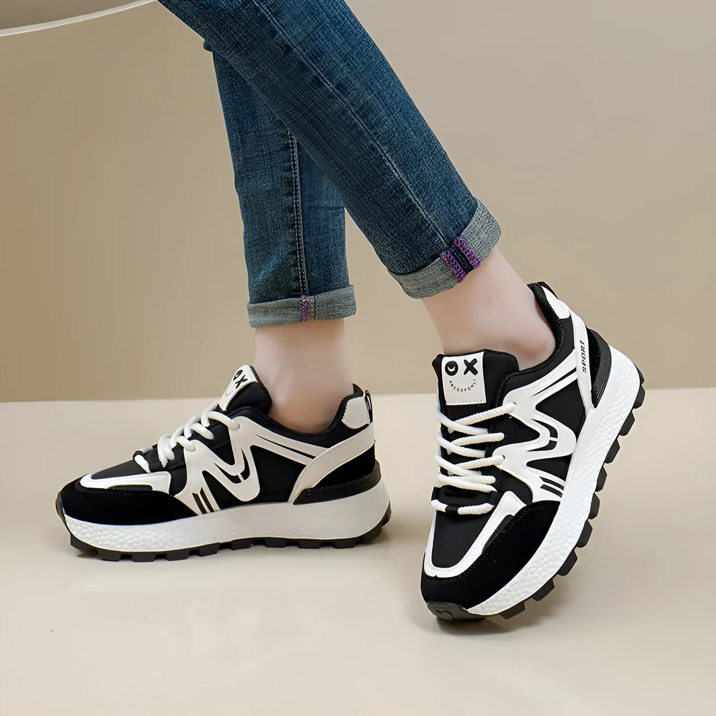 Women's flat-heel casual sports shoes in black with round toe and front lace-up design.