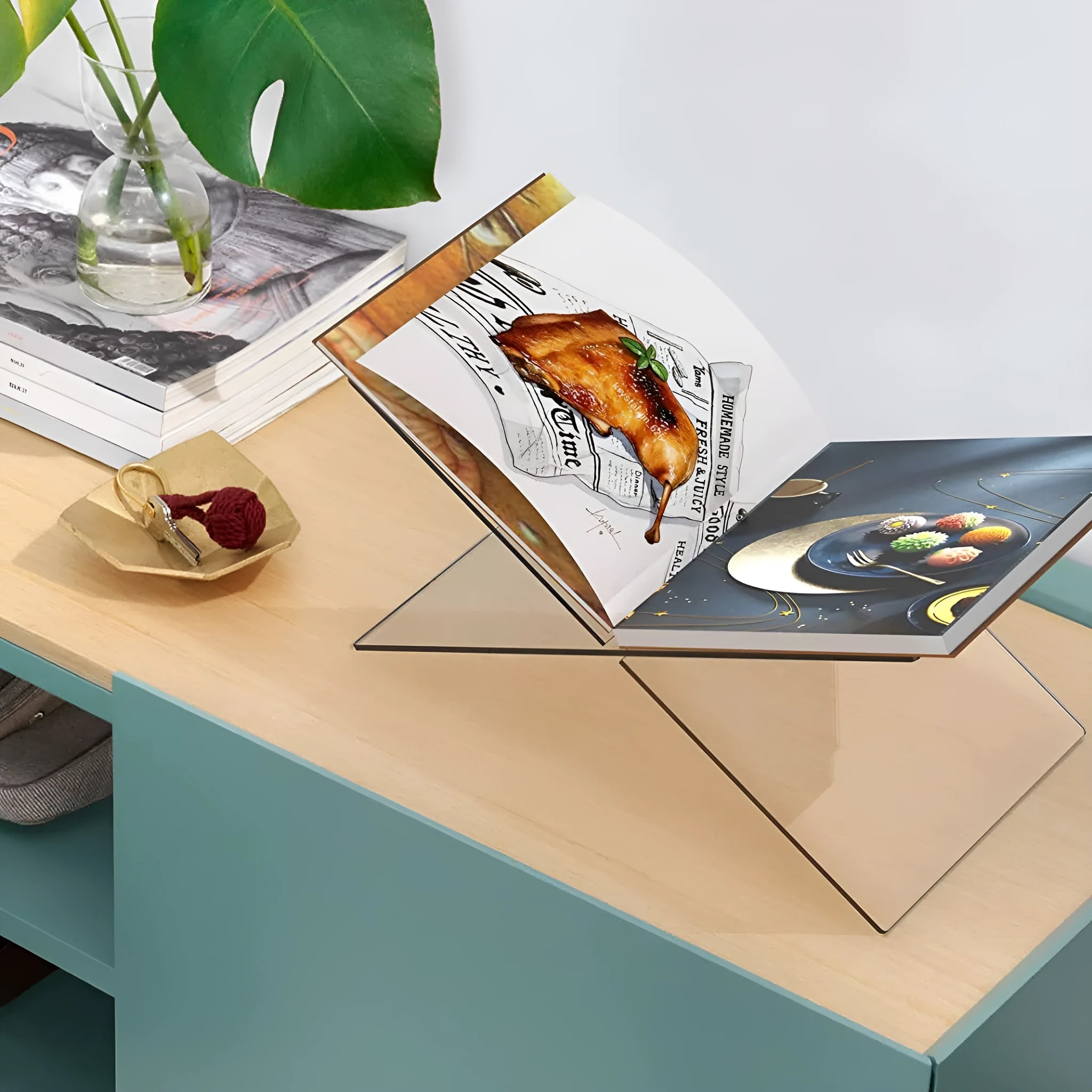 Clear acrylic X-shaped book reading rack displaying books on desktop