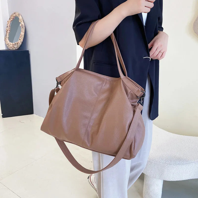 Large PU leather messenger bag with adjustable shoulder strap showing interior phone pocket organisation