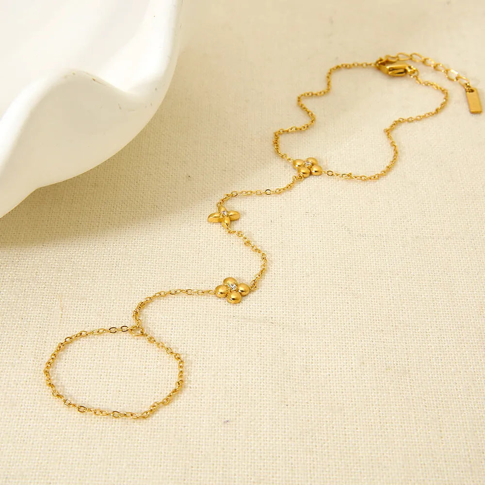 Gold stainless steel bracelet with eight pointed star and flower charms