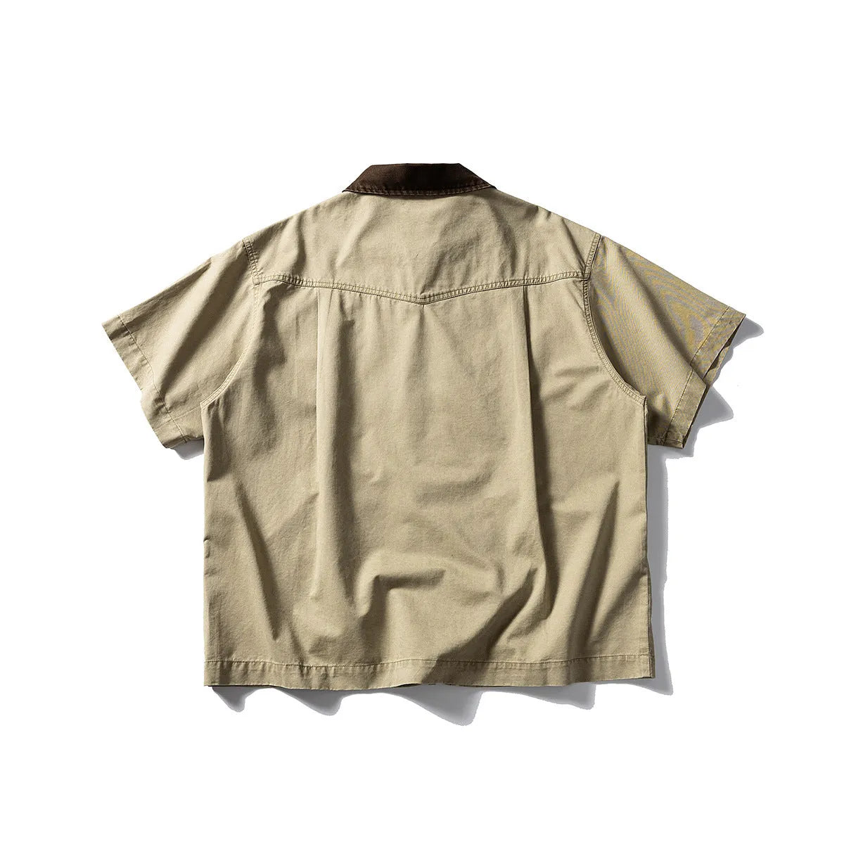 A man's khaki loose-fit short-sleeve cotton overalls shirt with button front and patch pockets.