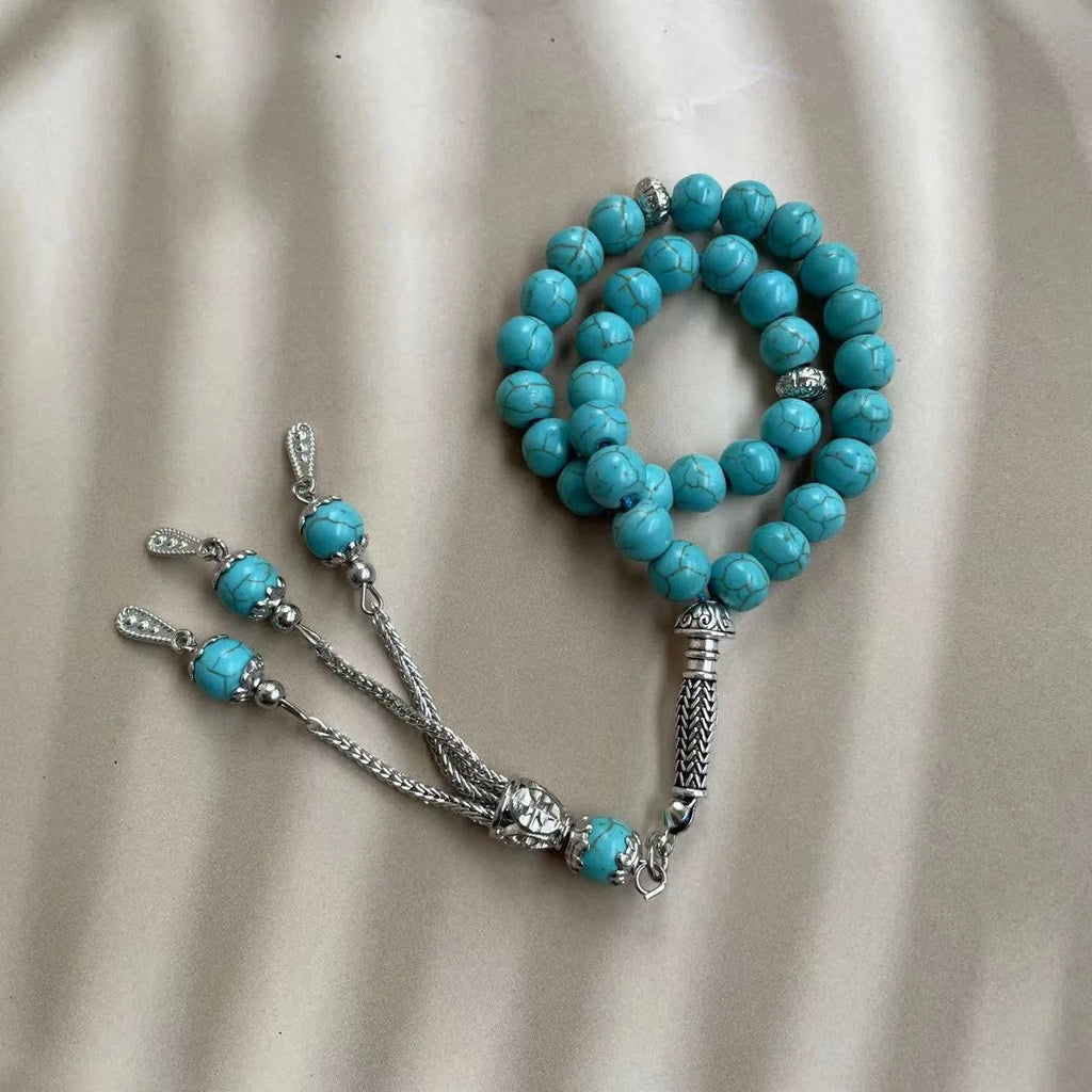 Sky blue stone bead Muslim prayer bracelet with sliding knot on a wrist.