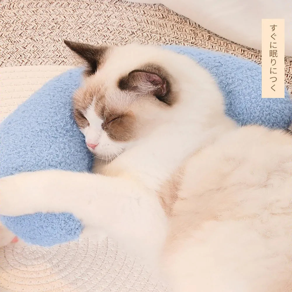 Blue U-shaped cat pillow with an adjustable fabric collar on a grey sofa