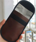 Black microfibre Faraday pouch for blocking car key, phone, and bank card signals, shown with a key fob inside.