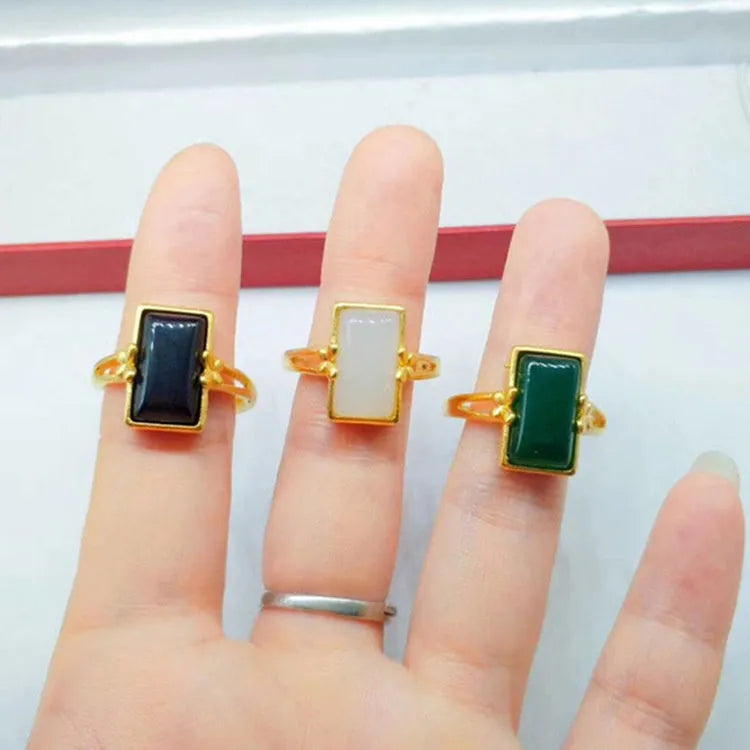 Adjustable gold-plated brass ring with a black gemstone inlay on a model's hand.