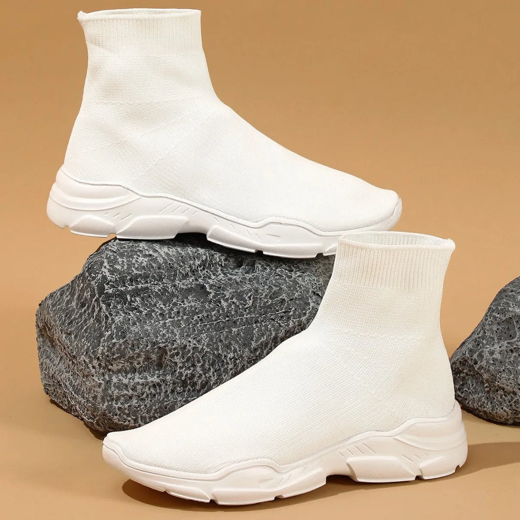 Thick-soled slip-on casual shoes in black with fabric upper, mid-top design, and round toe.