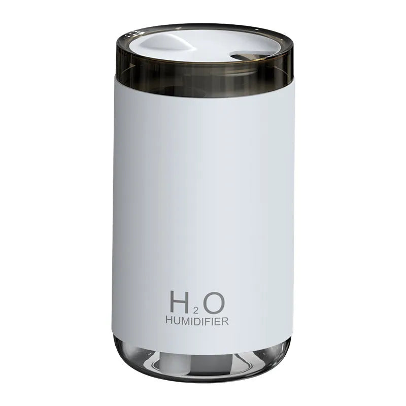 White USB humidifier with jellyfish spray mist effect and warm night light on a table.